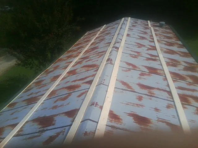 Rusted metal roof panels with new wood purlins before replacement — Storm Damage Roof Repair in Lilly by Roofing Brothers